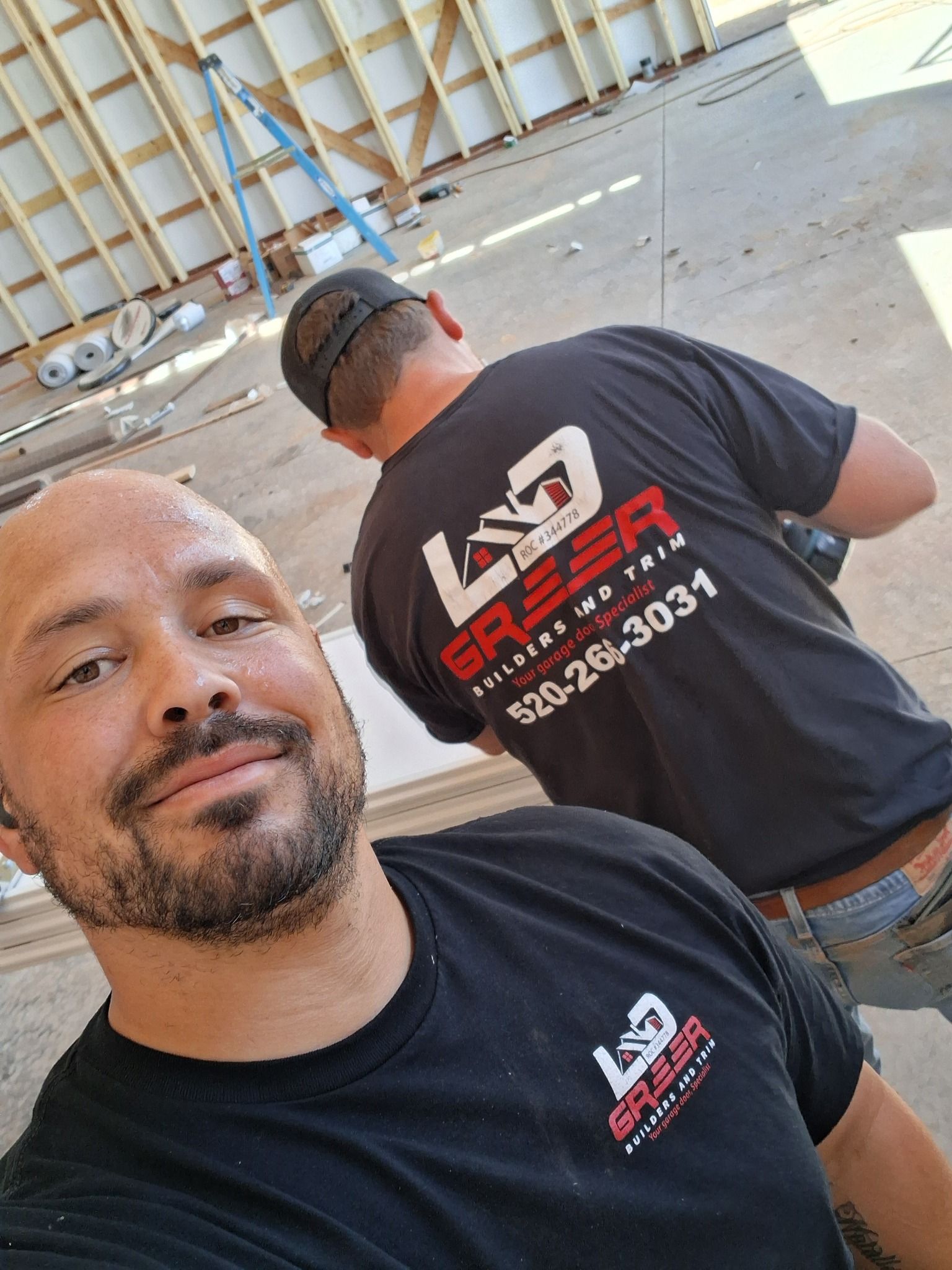 Two men are standing next to each other wearing black shirts.