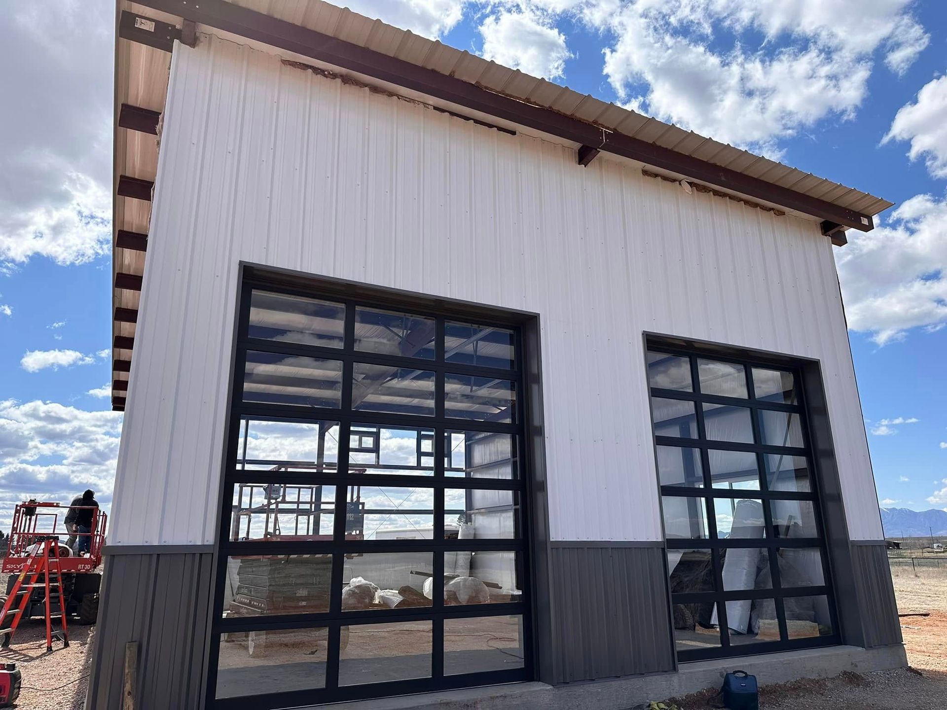 A building with a lot of windows and a garage door is being built.