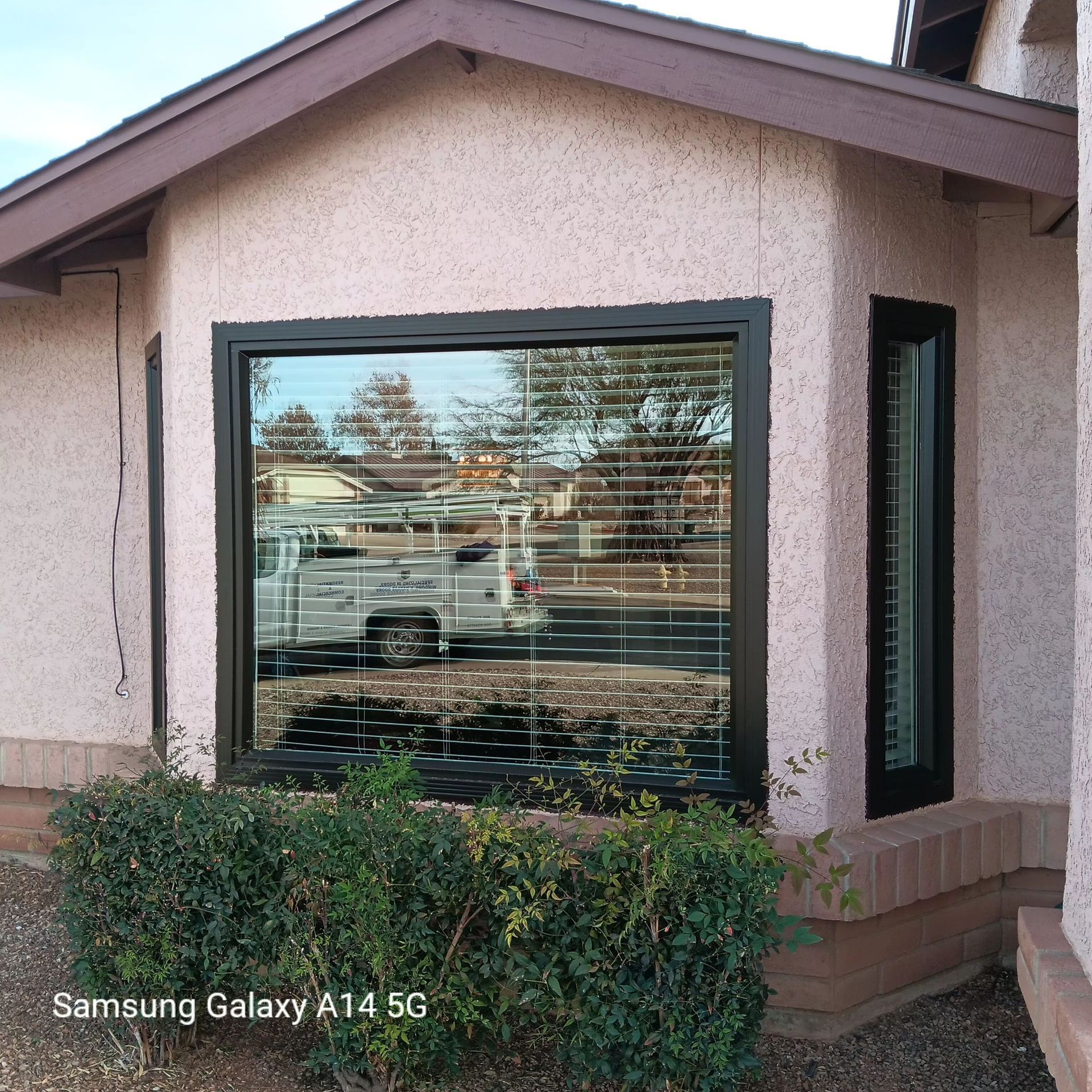 A samsung galaxy a14 5g is being used to take a picture of a house