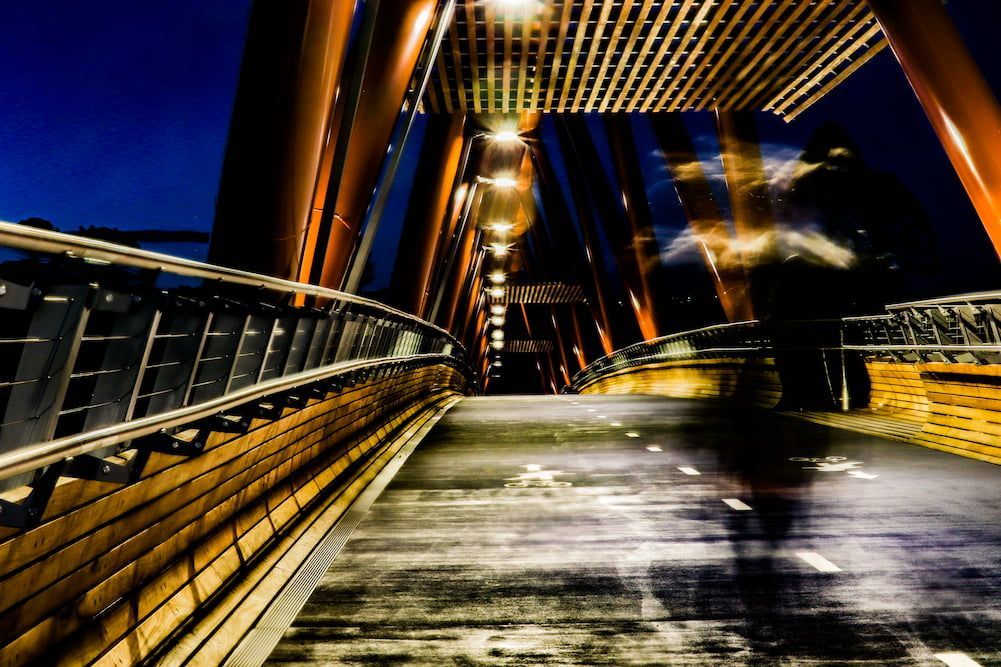 A Person Is Walking Across a Bridge at Night — Rearden Fencing Pty Ltd in Heatherbrae, NSW