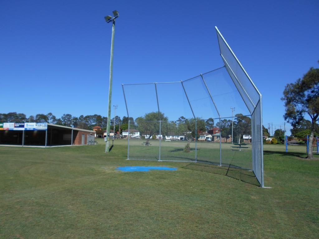 A Baseball Field with A Fence and A Building in The Background — Rearden Fencing Pty Ltd in Wallsend, NSW