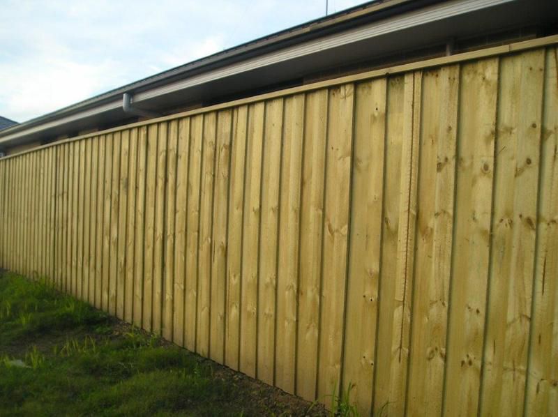 A Wooden Fence is Sitting in Front of a House — Rearden Fencing Pty Ltd in Toronto, NSW