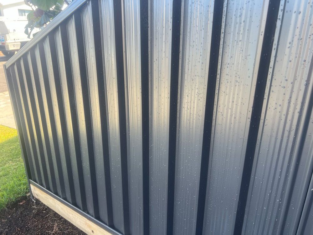 A Close Up of a Black Metal Fence With a Black Trim — Rearden Fencing Pty Ltd in Toronto, NSW