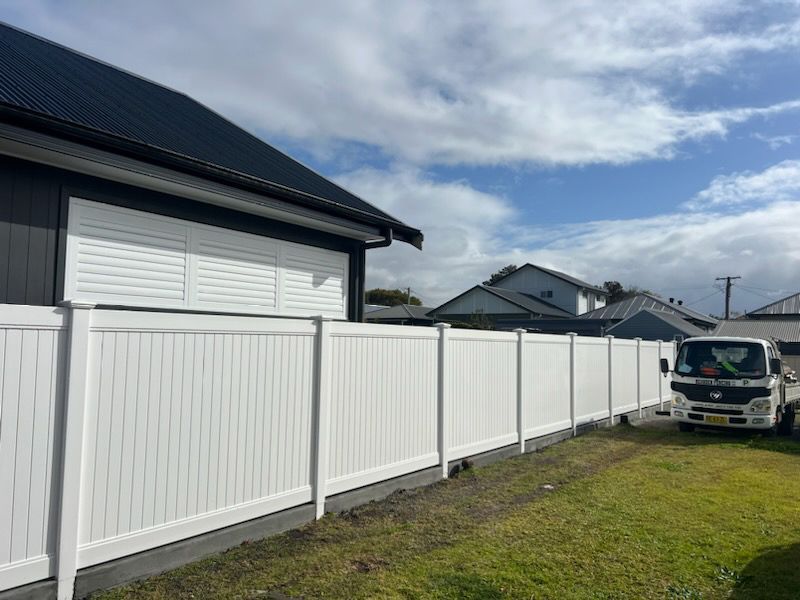 A White Truck is Parked in Front of a White Fence — Rearden Fencing Pty Ltd in Toronto, NSW