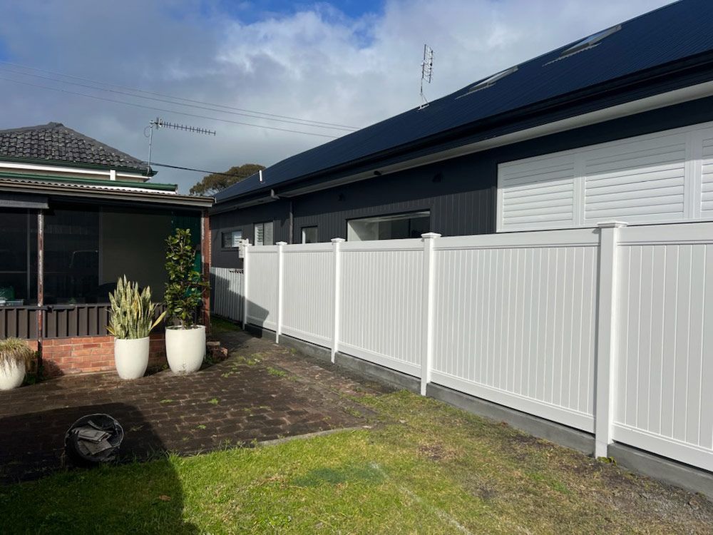 There is a White Fence in the Backyard of a House — Rearden Fencing Pty Ltd in Toronto, NSW