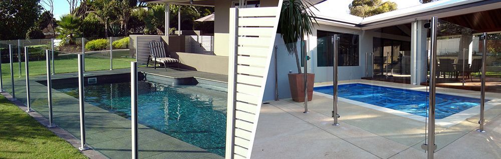 There is a Swimming Pool Behind a Glass Fence — Rearden Fencing Pty Ltd in Toronto, NSW