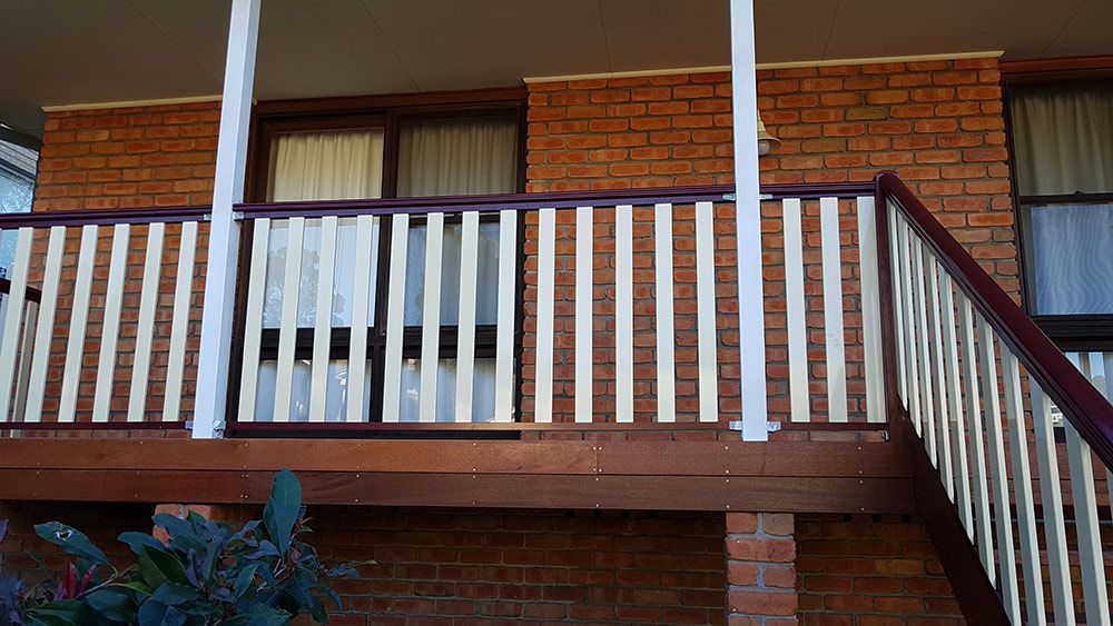 A Brick Building With a Balcony and Stairs Leading Up to It — Rearden Fencing Pty Ltd in Toronto, NSW