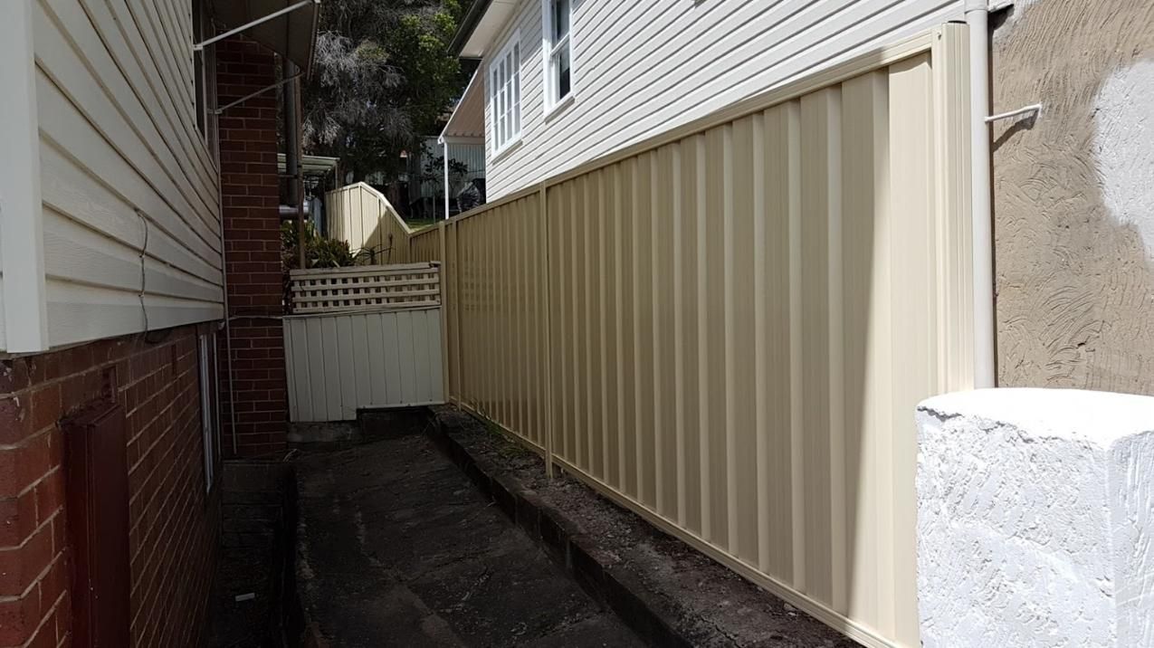 A Narrow Alleyway Between Two Houses with A White Fence — Rearden Fencing Pty Ltd in Greta, NSW