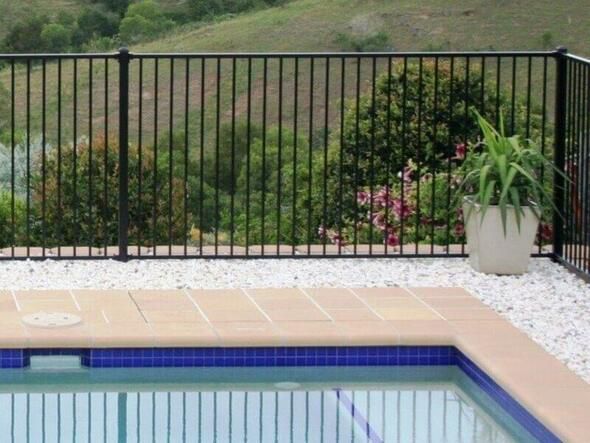 A Swimming Pool With a Black Fence Around It — Rearden Fencing Pty Ltd in Toronto, NSW