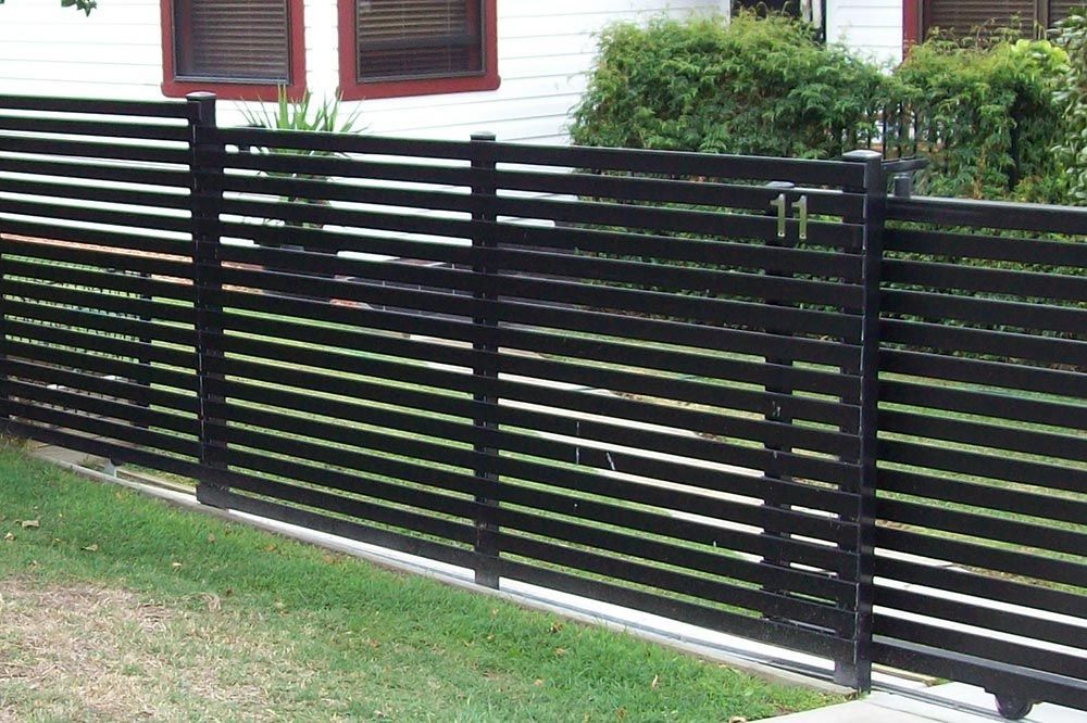 A Black Fence is in Front of a White House — Rearden Fencing Pty Ltd in Toronto, NSW
