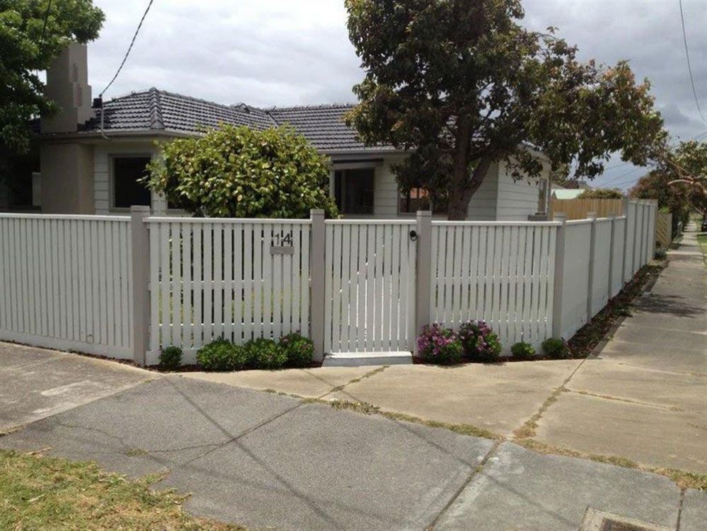 A White Picket Fence Surrounds a House With the Number 54 on It — Rearden Fencing Pty Ltd in Toronto, NSW