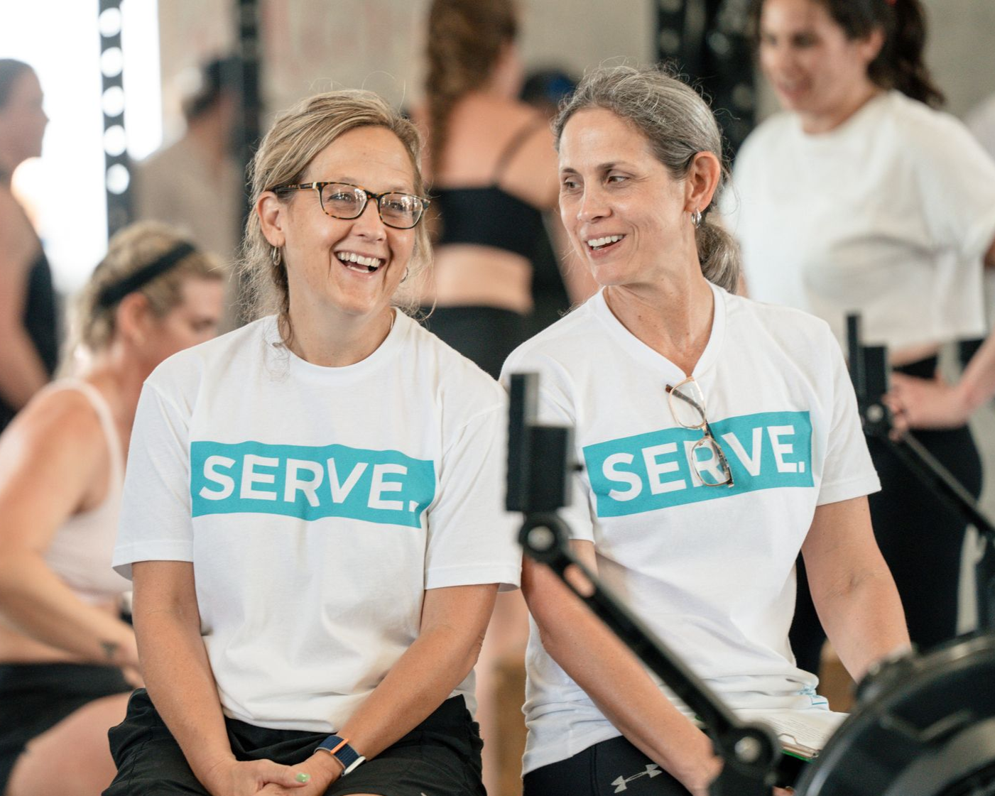 Two women smiling, wearing 