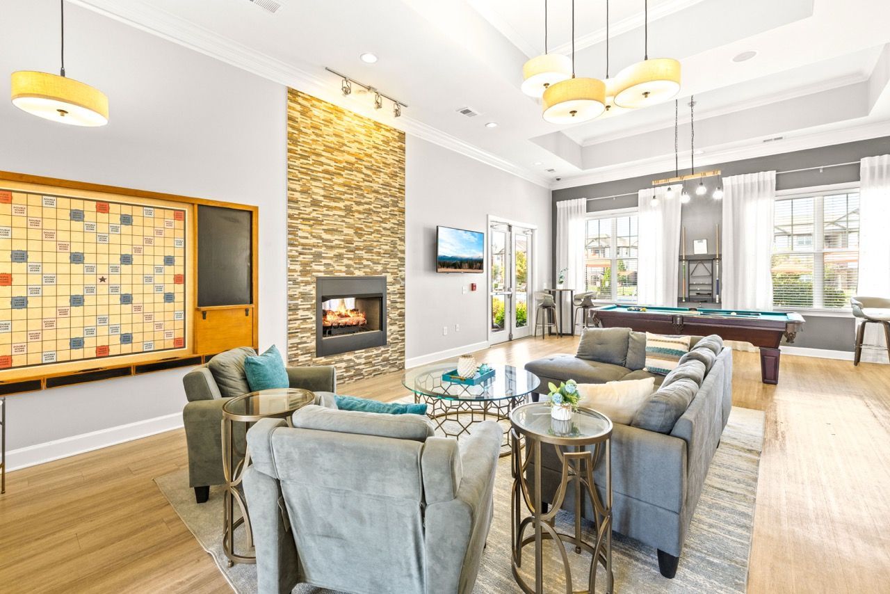 Bright communal lounge with fireplace, TV, and a pool table by large windows.