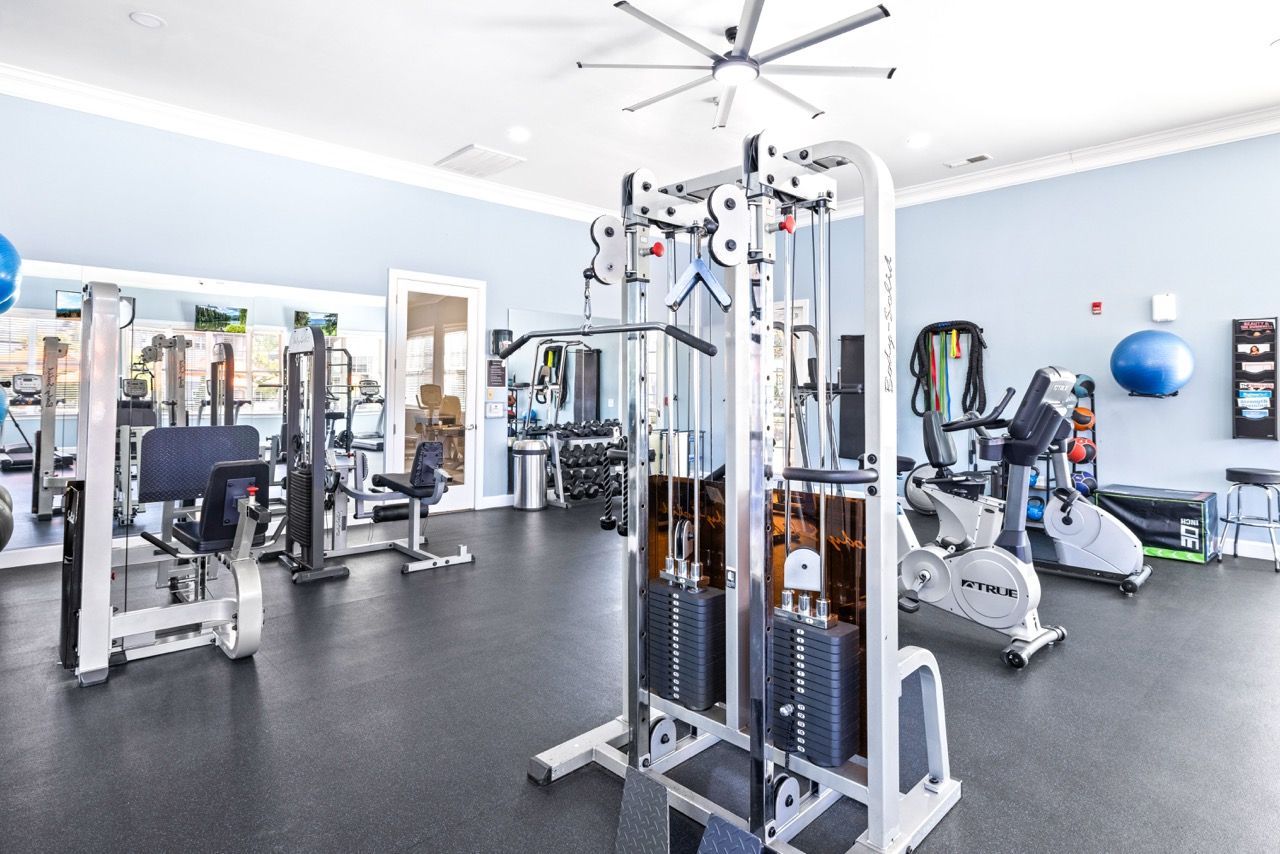 Interior view of a modern communal fitness center with weight machines and cardio equipment.