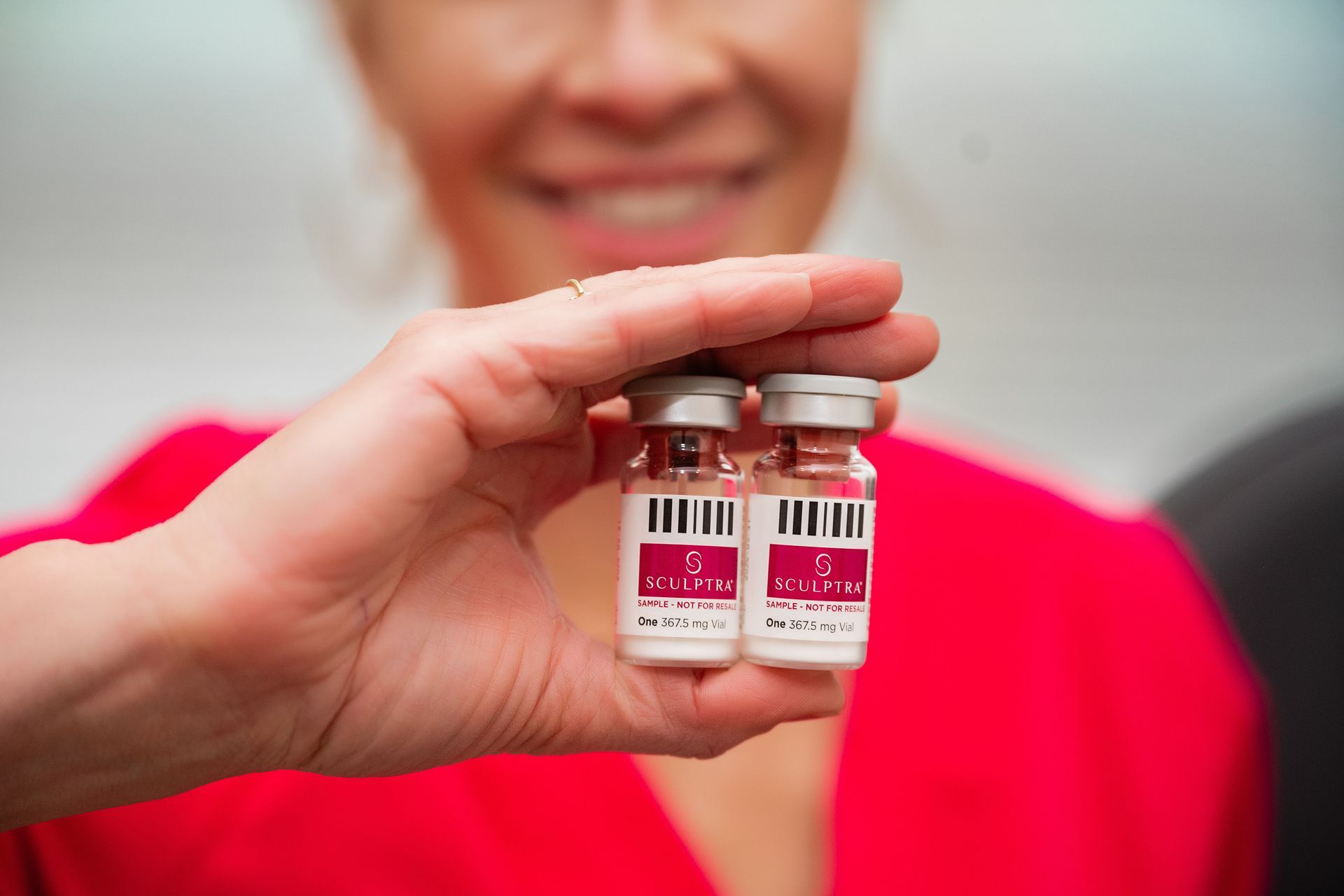 a woman is holding two bottles of vaccine in her hand .