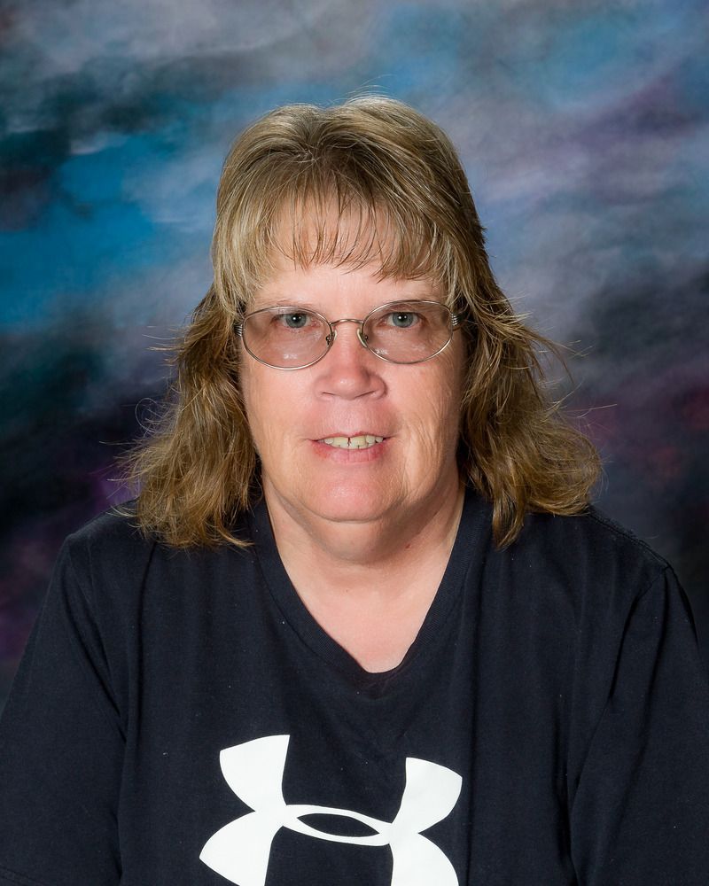 A woman wearing glasses and a black under armour shirt