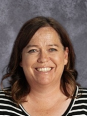 A woman wearing a black and white striped shirt is smiling for the camera.
