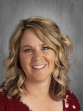 A woman with blonde hair and blue eyes is smiling for the camera.