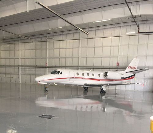 A white and red airplane is parked in a hangar.