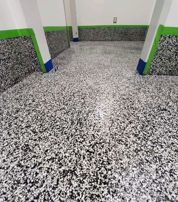 A black and white floor with green trim in a room.