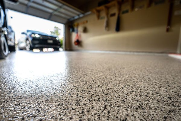 A car is parked in a garage with a concrete floor.