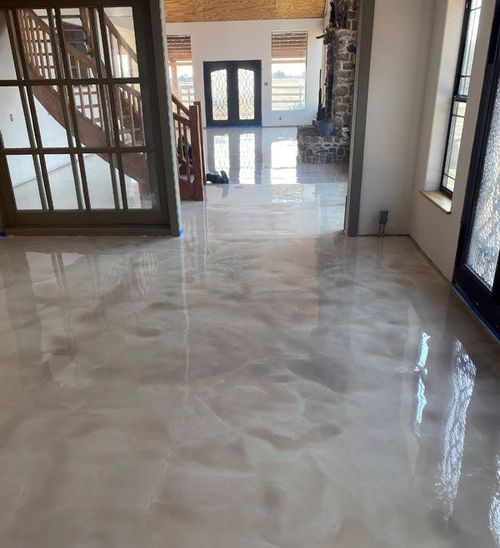 A living room with a marble floor and stairs