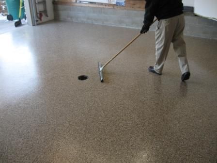 A man is sweeping the floor with a broom.