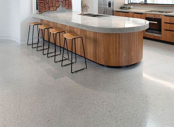 A kitchen with a large wooden island and stools.