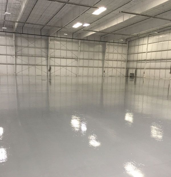 A large warehouse with a shiny floor and white walls.