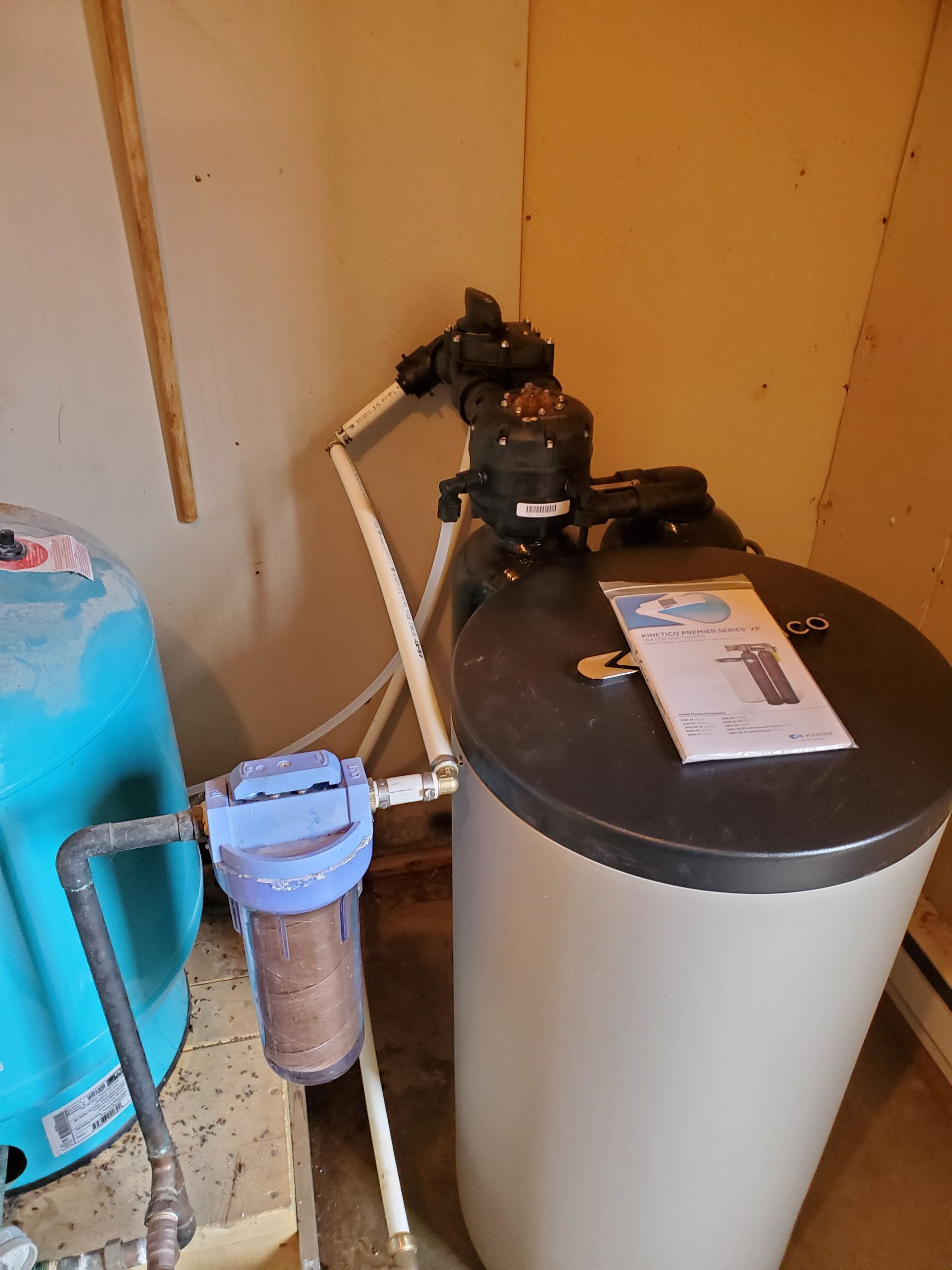 Water filtration system with tank and filter in a room.