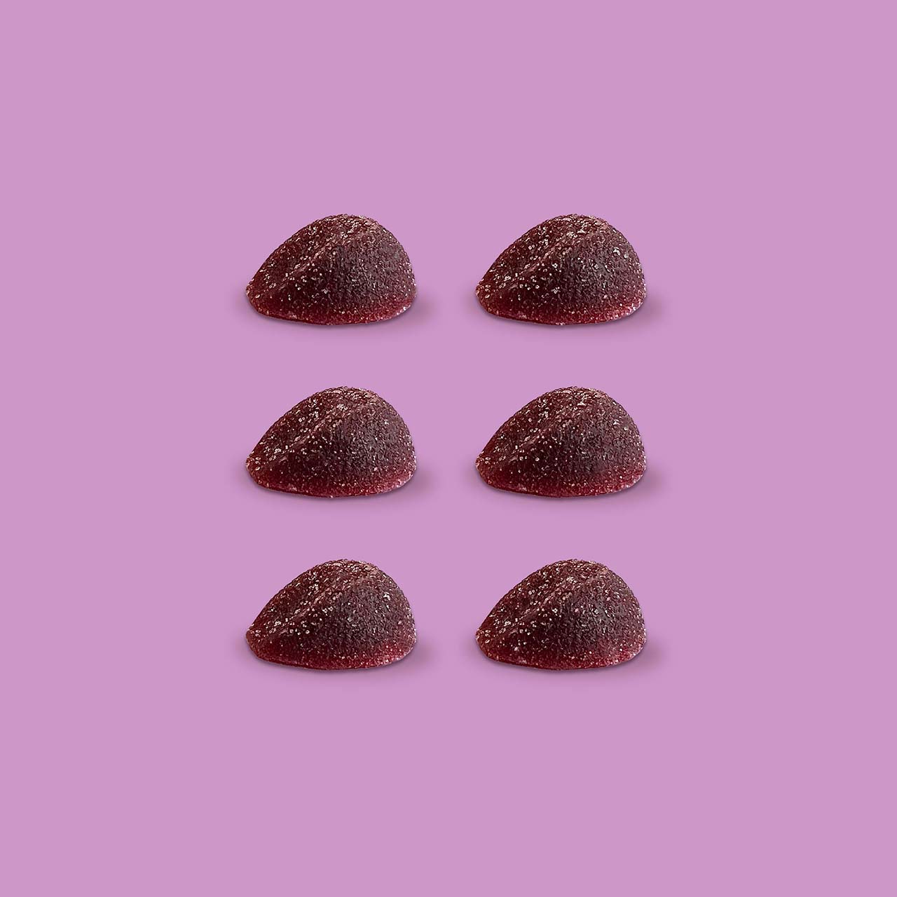 close up of six purple gummies on pink background