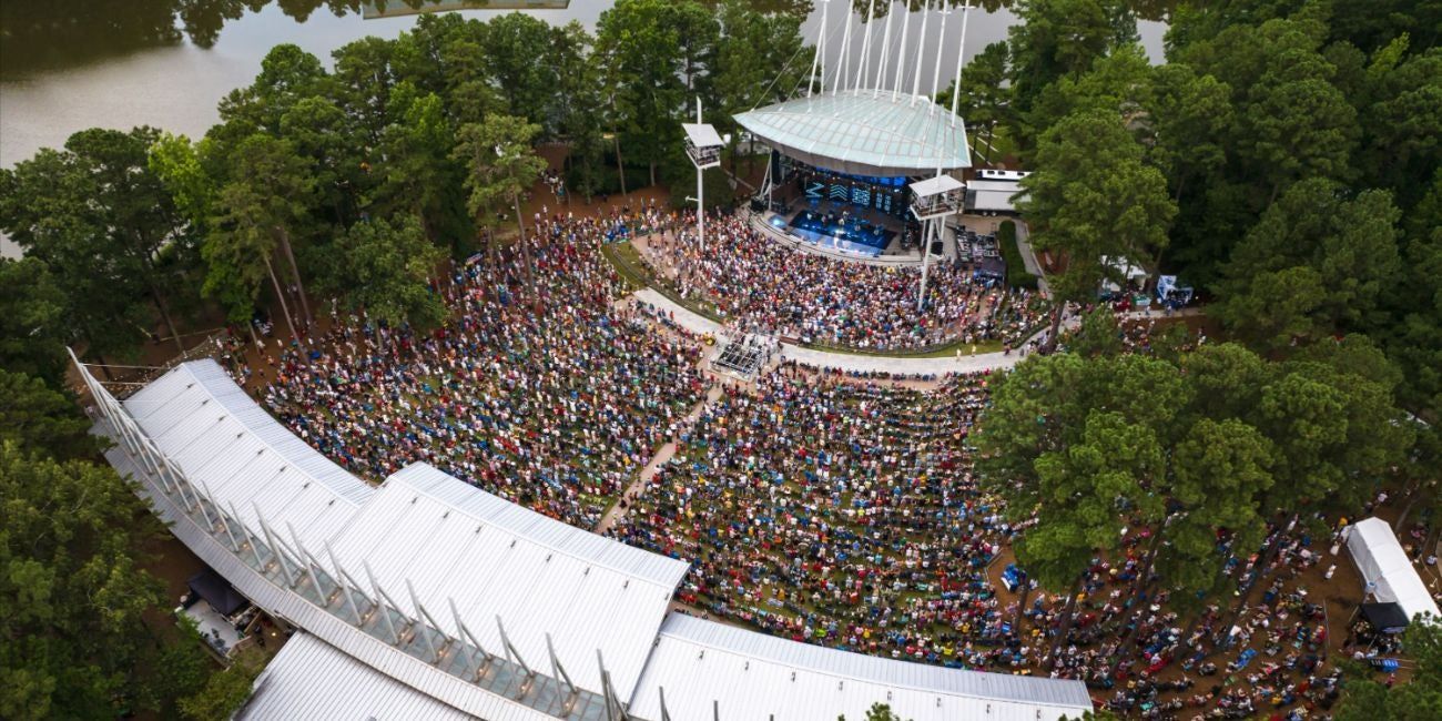 An outdoor amphitheater packed with a crowd watching a performance.
