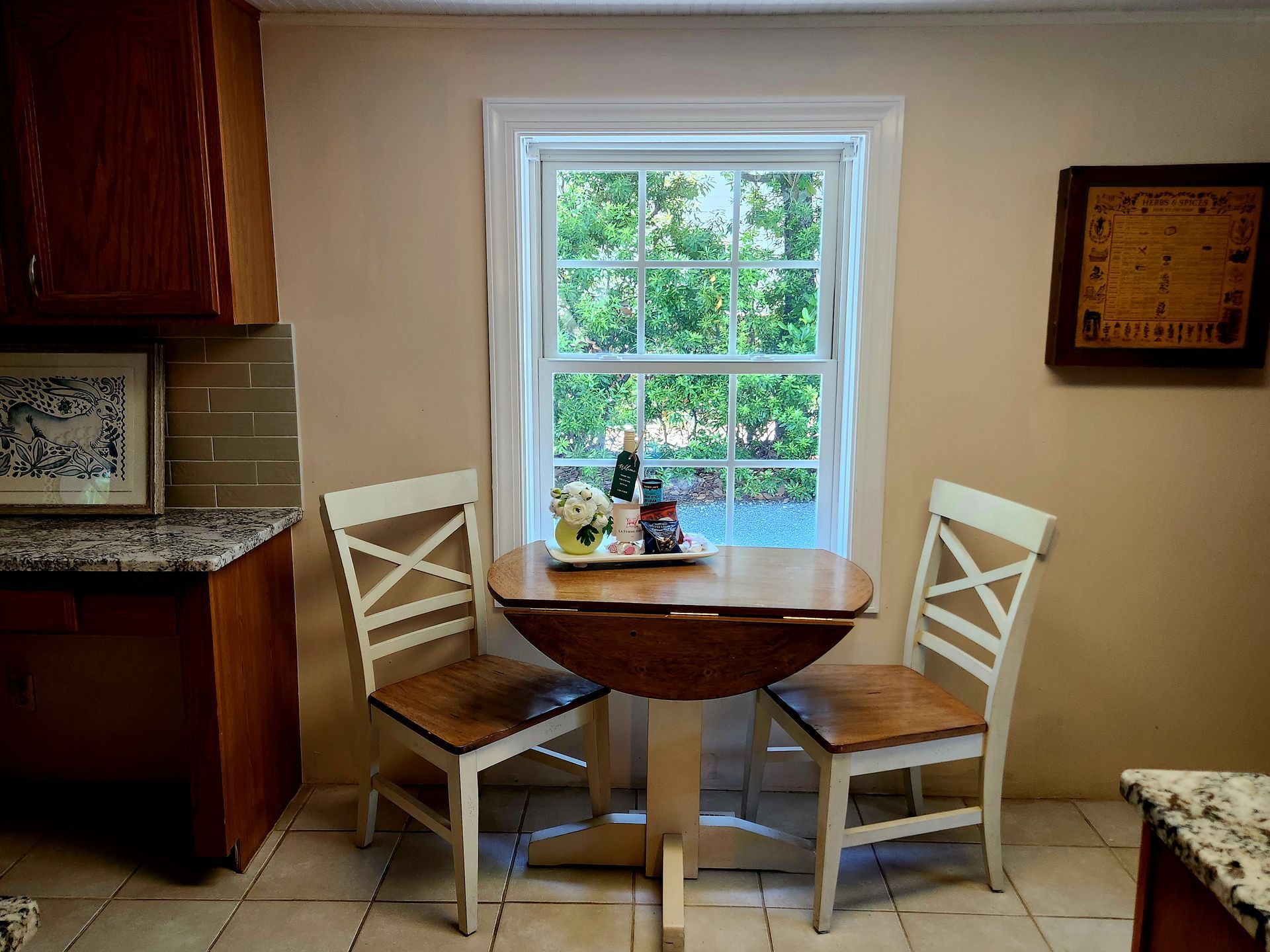 Small kitchen with a round table, two chairs, and a window with a view.
