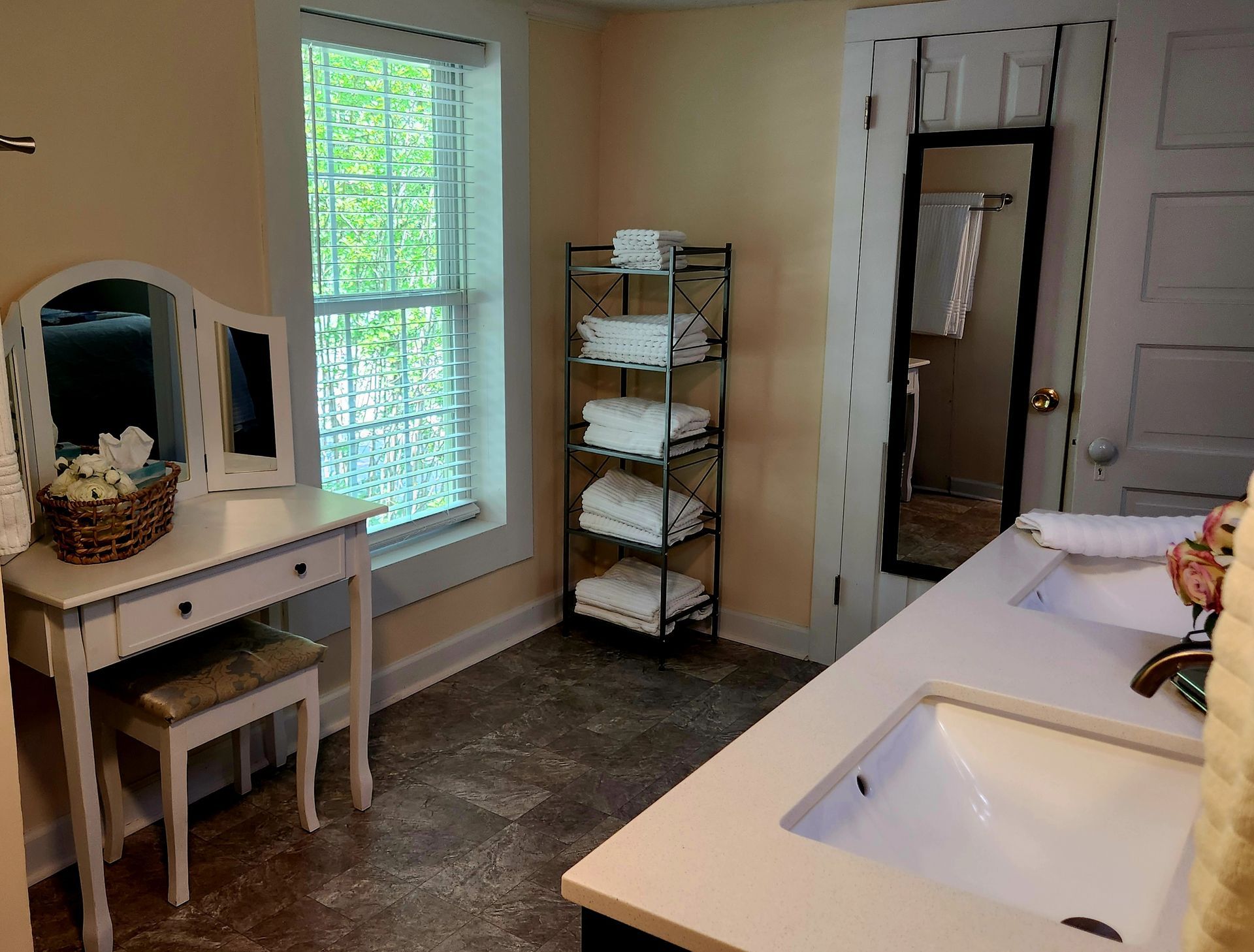 Bathroom with vanity, window, towels, and double sinks.