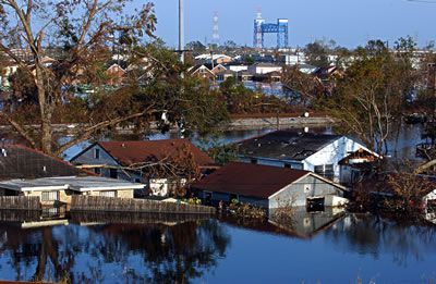 A flooded neighborhood with a water tower in the background