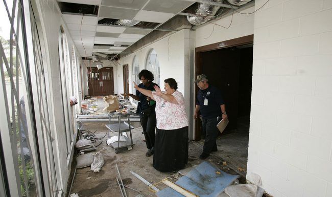 A group of people are standing in a hallway of a building.