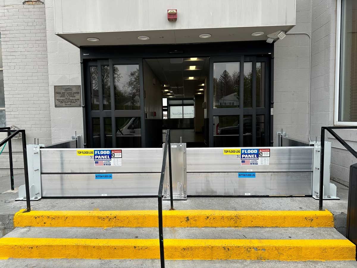 A building with a flood barrier in front of it and yellow steps.