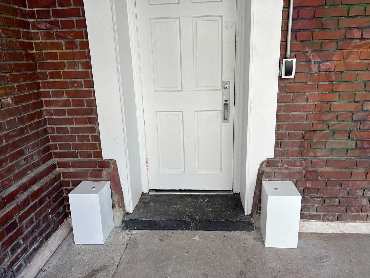 A white door with a brick wall behind it