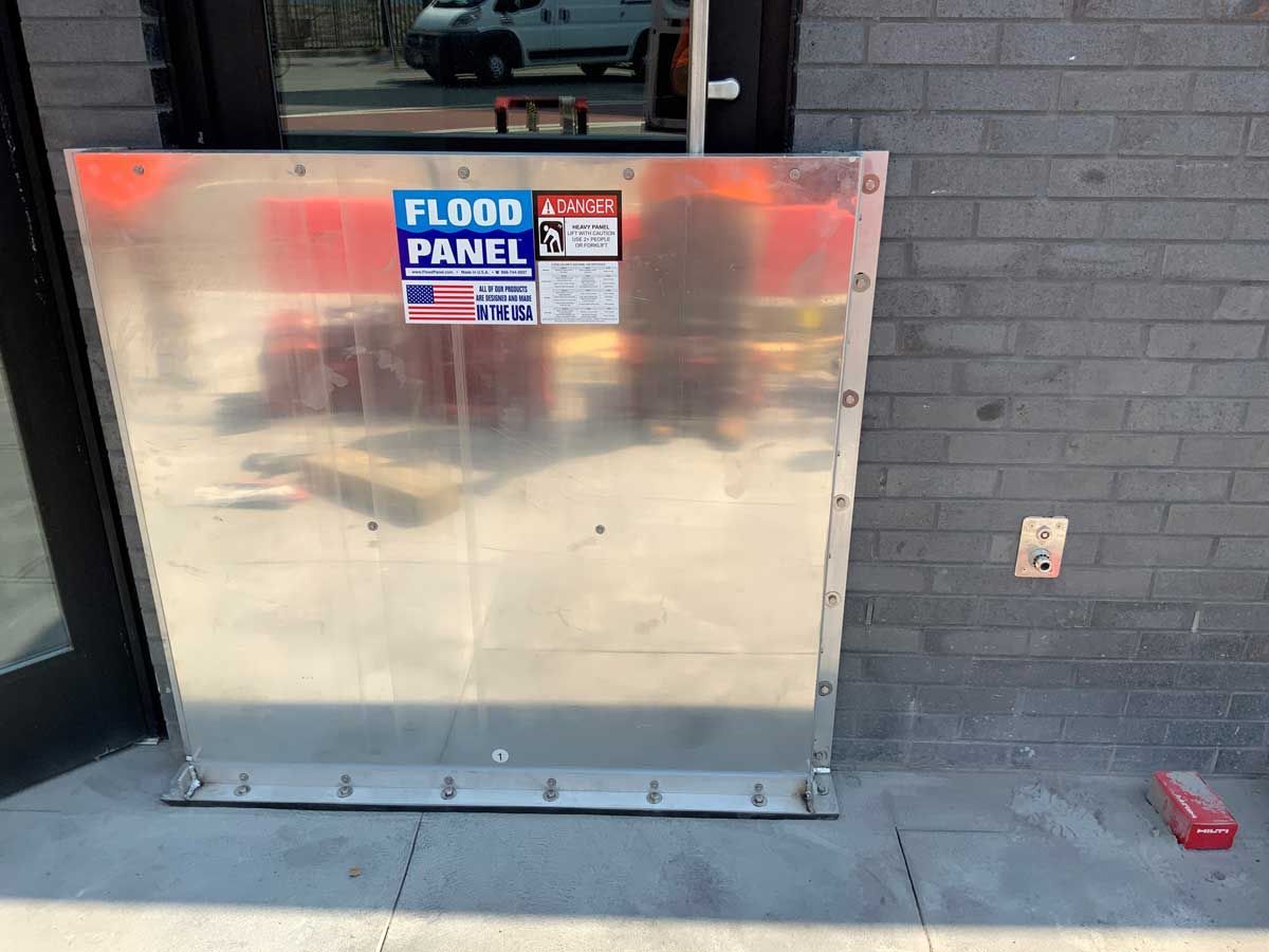 A flood panel is attached to the side of a building