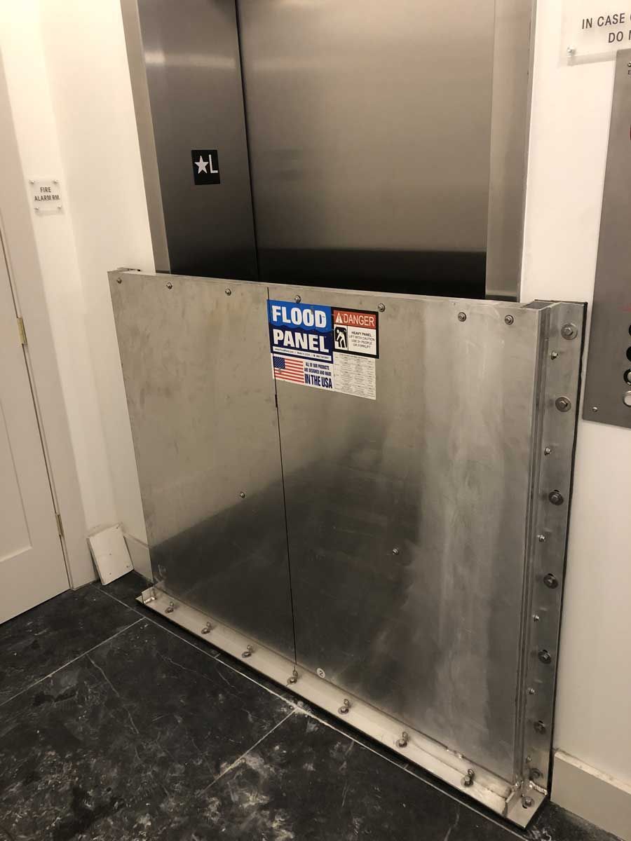 A stainless steel flood panel is sitting in front of an elevator.