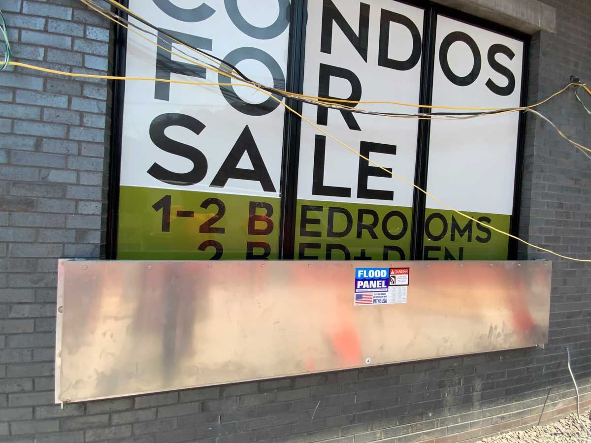 A condos for sale sign on a brick wall