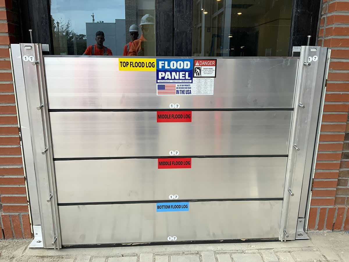A flood panel is sitting in front of a brick building
