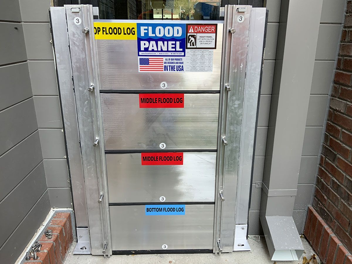 A stainless steel flood panel is sitting on the side of a building.