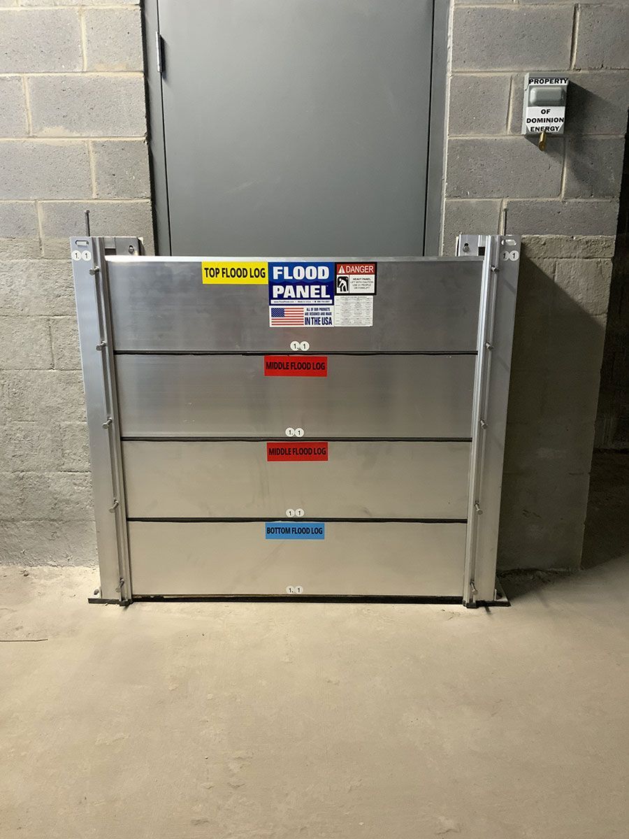 A flood barrier is sitting in front of a brick wall.