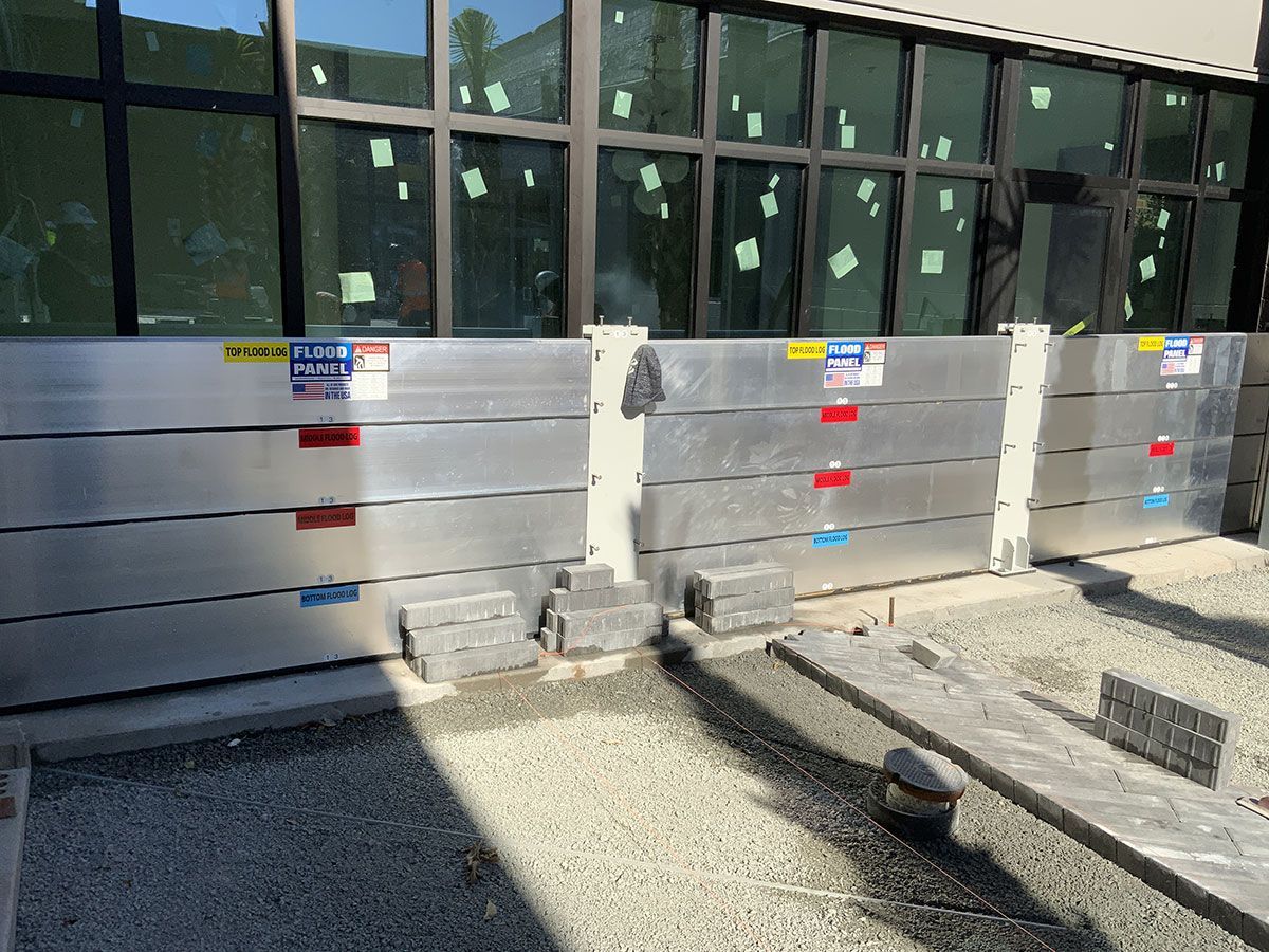 A row of aluminum barriers are sitting in front of a building.