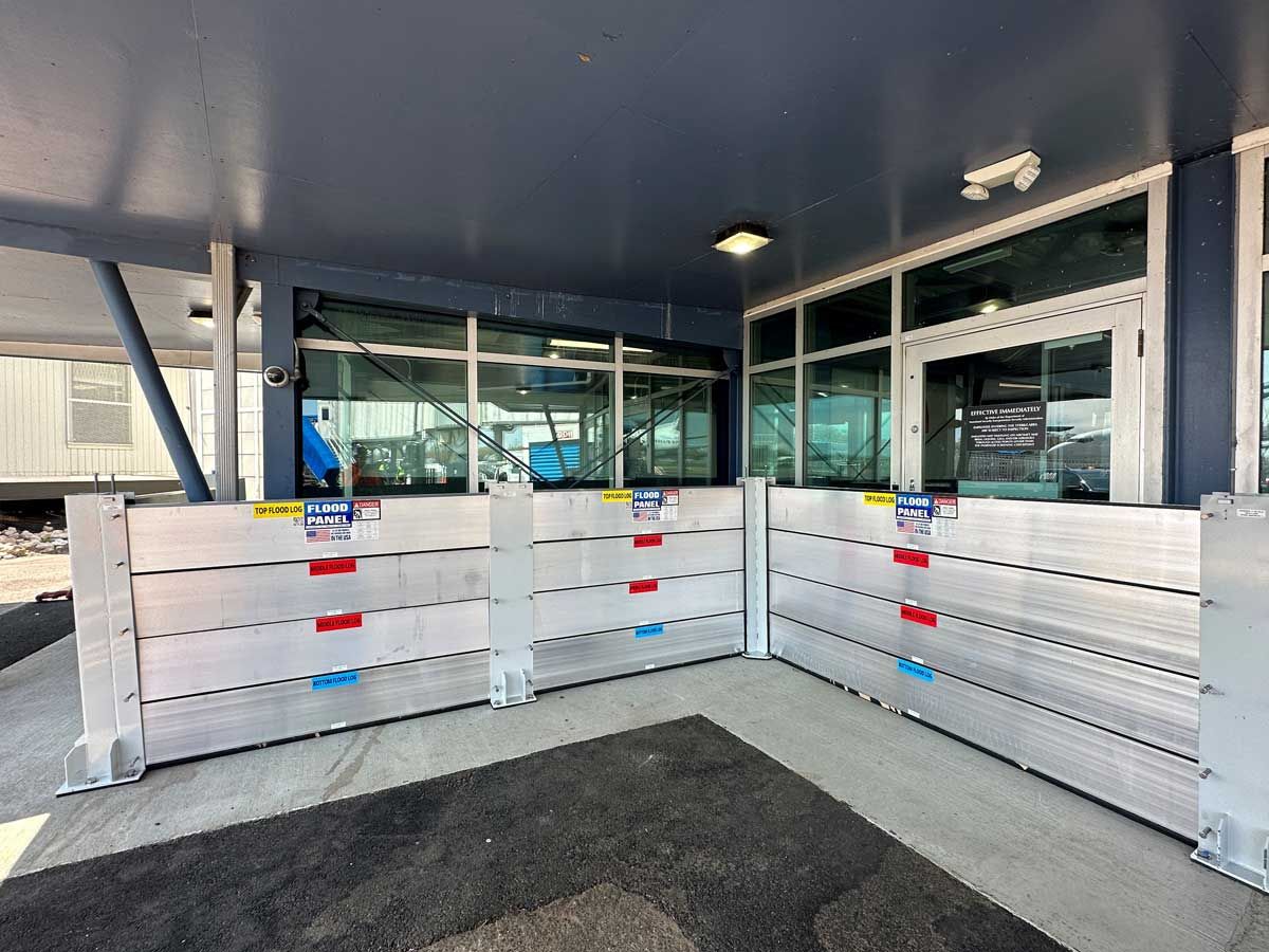 A building with a lot of windows and a flood barrier in front of it.