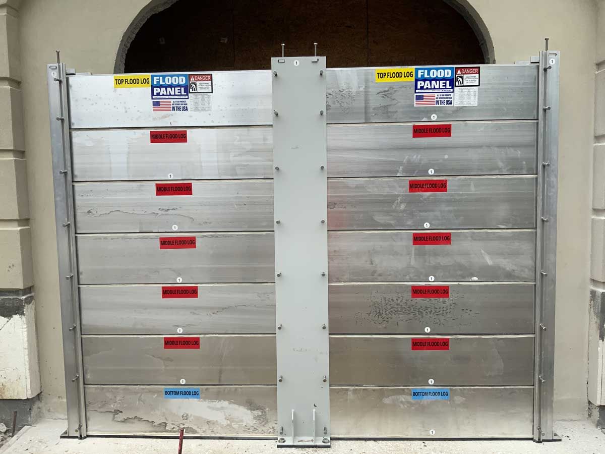 A pair of aluminum flood barriers are sitting in front of a building