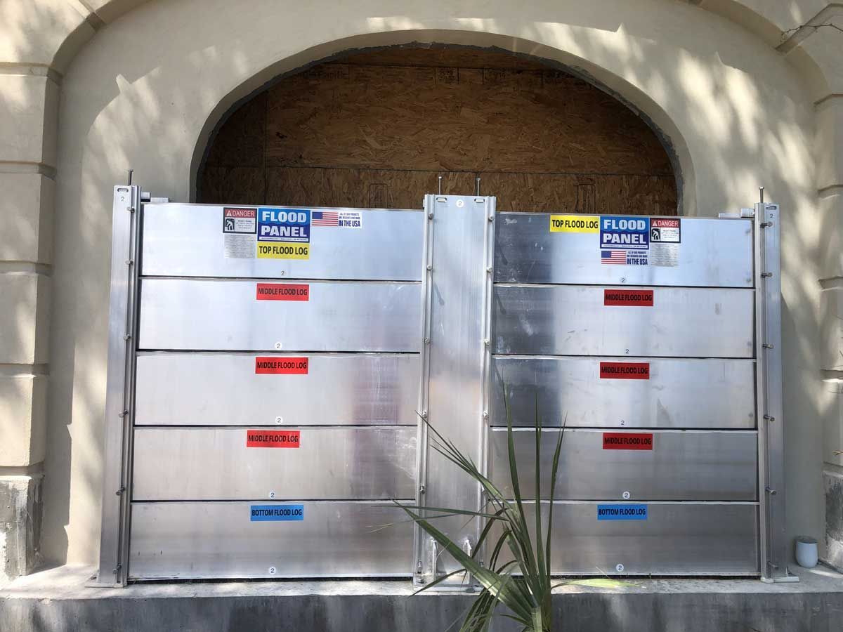 Two aluminum flood barriers on the side of a building