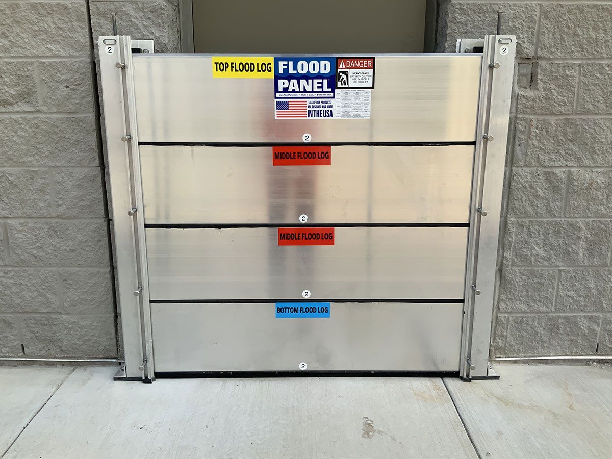 A stainless steel flood panel is sitting on the sidewalk