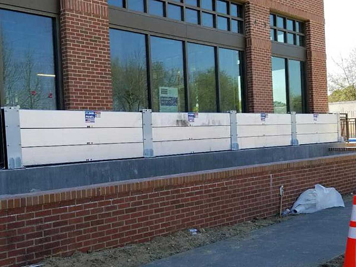 A brick building with a row of white barriers in front of it